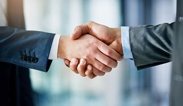 Closeup of two businesspeople shaking hands in an office