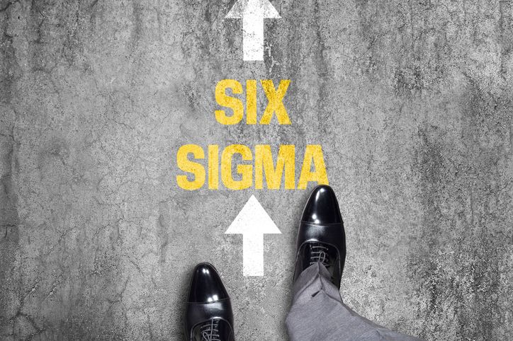 Aerial view of businessman walking in the direction of Six Sigma text