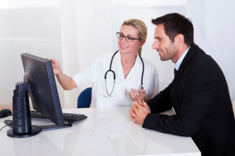 image of IT professional sitting and working with a healthcare professional