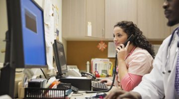 Female medical professional on the phone speaking to a patient.