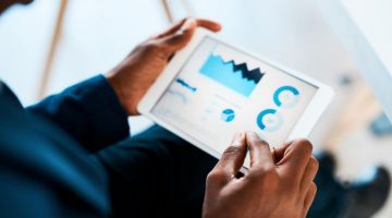 Businesswoman using a tablet with business data on it in an office.