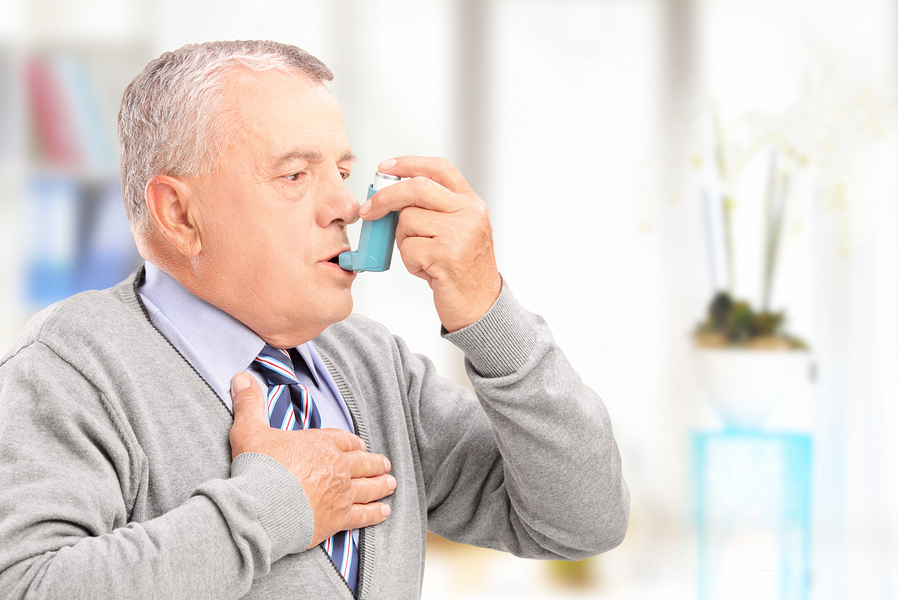 image of an elderly man using his inhaler